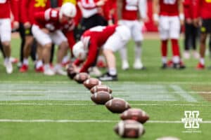 Footballs lined up for a long snapper competition during Husker games Saturday, April 26, 2025 in Lincoln, Nebraska. Photo by John S. Peterson.