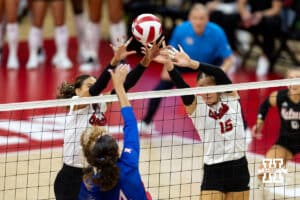 Nebraska Cornhusker Skyler Pierce (21) and Andi Jackson (15) jump up to block Kansas Jayhawk Rhian Swanson (4) during a college volleyball match Saturday, April 26, 2025 in Lincoln, Nebraska. Photo by John S. Peterson.