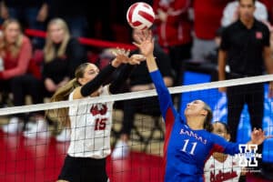 Nebraska Cornhusker Andi Jackson (15) jumps up to try and block Kansas Jayhawk Cristin Cline (11) during a college volleyball match Saturday, April 26, 2025 in Lincoln, Nebraska. Photo by John S. Peterson.