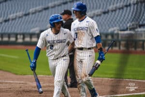 Creighton Bluejay Connor Capece gets the run in and talks with Matt Scherrman during a baseball game at Charles Schwab Field on Thursday, April 17th, 2025 in Omaha Nebraska. Photo by Collin Stilen.