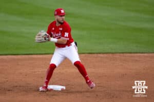 Nebraska Cornhusker second baseman Cayden Brumbaugh (0) throws to first trying to turn a double play against the Kansas Jayhawks during a college baseball game Tuesday, April 22, 2025 in Lincoln, Nebraska. Photo by John S. Peterson.