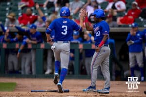 Kansas Jayhawk Brady Counsell (3) gives Dariel Osoria a high five after both scored against the Nebraska Cornhuskers during a college baseball game Tuesday, April 22, 2025 in Lincoln, Nebraska. Photo by John S. Peterson.