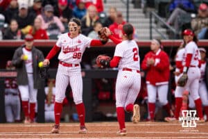 Nebraska Cornhusker Jordyn Bahl (98) gives a fist bump to Lauren Camenzind against the Indiana Hoosiers during a college softball game Friday, April 18, 2025 in Omaha, Nebraska. Photo by John S. Peterson.
