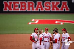 Nebraska Cornhuskers meet at the circle against the Indiana Hoosiers during a college softball game Friday, April 18, 2025 in Omaha, Nebraska. Photo by John S. Peterson.