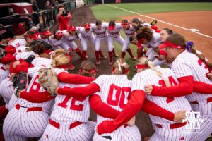 Nebraska Cornhuskers huddle up before taking on the Indiana Hoosiers during a college softball game Friday, April 18, 2025 in Omaha, Nebraska. Photo by John S. Peterson.