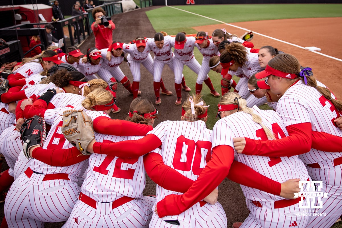 Nebraska Cornhuskers huddle up before taking on the Indiana Hoosiers during a college softball game Friday, April 18, 2025 in Omaha, Nebraska. Photo by John S. Peterson.