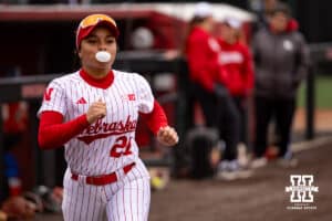 Nebraska Cornhusker Natalia Hill (27) runs out for intros blowing a bubble against the Indiana Hoosiers during a college softball game Friday, April 18, 2025 in Omaha, Nebraska. Photo by John S. Peterson.