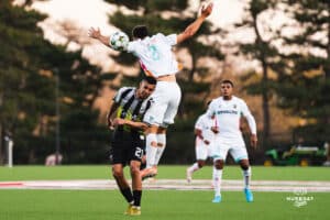 Union Omaha Aarón Gómez caught up with a defender during a soccer game at Caniglia Field on Tuesday, April 15, 2025, in Omaha, Nebraska. Photo by Collin Stilen.