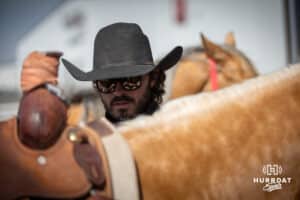 Taylor Cook tightens up the saddle on Bud preparing the horses for a day at the John Cook Roping Clinic on Saturday, April 12, 2025 in Lincoln, Nebraska. Photo by John S. Peterson.