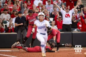 Nebraska Cornhusker catcher Ava Bredwell (24) dives to make an out against Creighton Bluejay Ashten Pierson (4) during a college softball game Wednesday,April 4, 2025 in Lincoln, Nebraska. Photo by John S. Peterson.