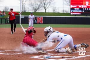 Nebraska Cornhusker Hannah Camenzind (9) slide at home for a run against Creighton Bluejay catcher Lily West (8) in the first inning during a college softball game Wednesday,April 4, 2025 in Lincoln, Nebraska. Photo by John S. Peterson.