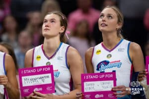 Omaha Supernovas Lindsay Krause and Ally Batenhorst holding up signs saying who the stand up for Lindsay's mom Joanna in the fight against cancer at the break after the first set during a professional volleyball match against the Orlando Valkyries Saturday, April 5, 2025 in Omaha, Nebraska. Photo by John S. Peterson.