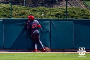 Rutgers Scarlet Knight outfielder Peyton Bonds (25) runs into the wall allowing Nebraska Cornhusker Devin Nunez (16) to score in the eighth during a college baseball game Sunday, April 6, 2025 in Lincoln, Nebraska. Photo by John S. Peterson.