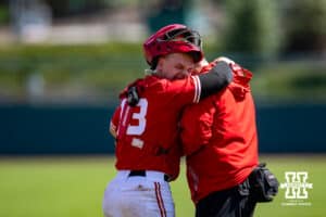 Nebraska Cornhusker catcher Will Jesske (13) is having the trainer look at his wirst after a play at the plate against the Rutgers Scarlet Knights in the sixth inning during a college baseball game Sunday, April 6, 2025 in Lincoln, Nebraska. Photo by John S. Peterson.