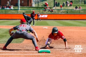 Nebraska Cornhusker infielder Dylan Carey (15) dives back to first base against the Rutgers Scarlet Knights during a college baseball game Sunday, April 6, 2025 in Lincoln, Nebraska. Photo by Jansen Coburn.