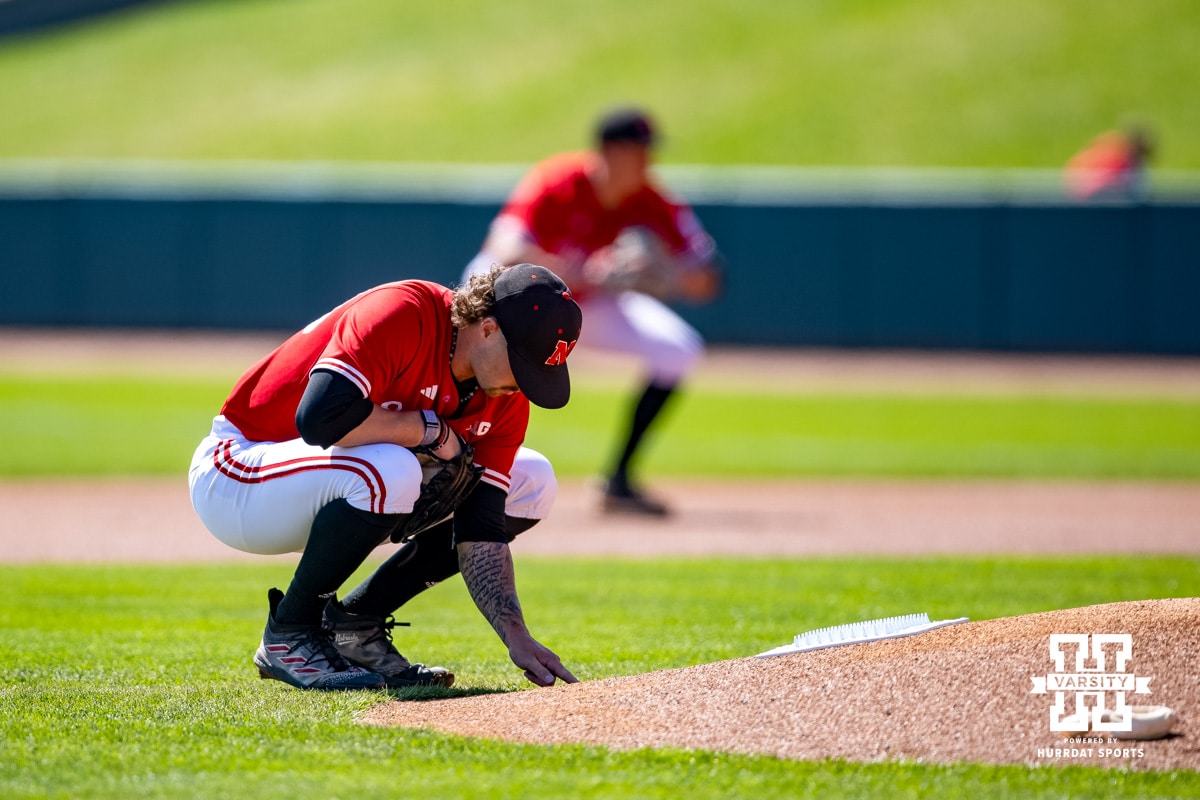 Nebraska Cornhusker pitcher Jackson Brockett (33) writes something on the back of the mound before pitching against the Rutgers Scarlet Knights during a college baseball game Sunday, April 6, 2025 in Lincoln, Nebraska. Photo by John S. Peterson.