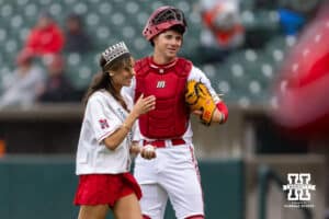 Nebraska Cornhusker catcher Will Jesske (13) gives the baseball to Miss Nebraska USA Kamryn Buchanan that she use for the opening pitch before a college baseball game against the Oregon State Beavers Saturday, March 29, 2025 in Lincoln, Nebraska. Photo by John S. Peterson.
