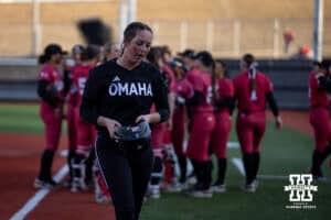 Omaha Maverick Rylee White (3) heads to the dugout as Nebraska Cornhuskers celebrates the win during a college softball game on Wednesday, March 26, 2025, in Omaha, Nebraska. Photo by John S. Peterson.