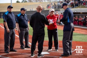 Nebraska Cornhusker head coach Rhonda Revelle and Omaha Maverick head coach Mike Heard meeting with the umpire before a college softball game on Wednesday, March 26, 2025, in Omaha, Nebraska. Photo by John S. Peterson.