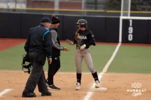 Omaha Mavericks Rylinn Groff high fives a coach during a college softball game against Creighton on April 1st, 2025 in Omaha, Nebraska. Photo by Brandon Tiedemann.