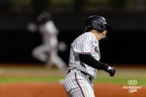 Omaha Maverick utility Sam Beck (21) heads home as Omaha Maverick utility Henry Zipay (1) rounds first hitting a triple in the fifth inning during a college baseball game Wednesday, April 2, 2025 in Omaha, Nebraska. Photo by John S. Peterson.