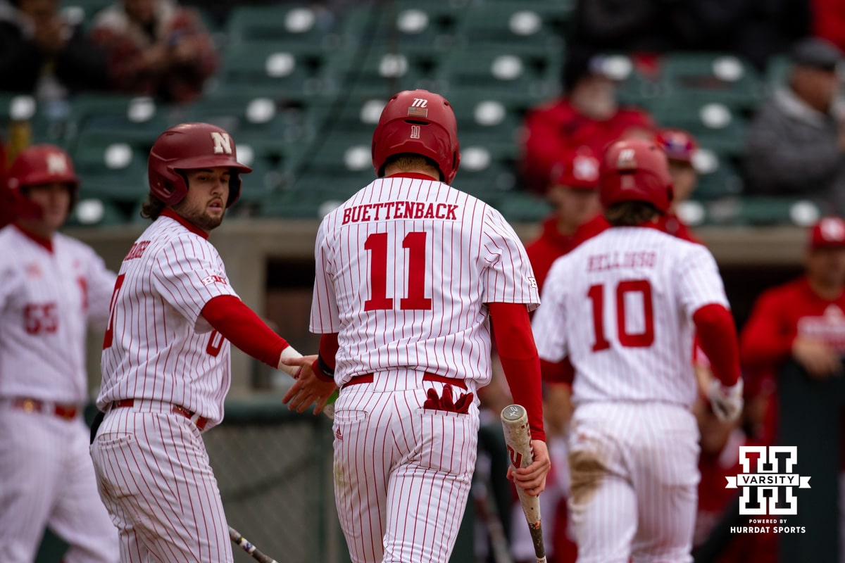 Nebraska Cornhusker utility Max Buettenback (11) gets a five from Cayden Brumbaugh heading to the dugout after scoring against the Creighton Bluejays in the second during a college baseball game Tuesday, April 1, 2025 in Lincoln, Nebraska. Photo by John S. Peterson.