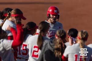 Nebraska Cornhusker Hannah Camenzind (9) crosses home plate with teammates ready to celebrate her homerun in the fifth inning against the Purdue Boilermakers during a college softball game Monday, March 31, 2025 in Lincoln, Nebraska. Photo by John S. Peterson.