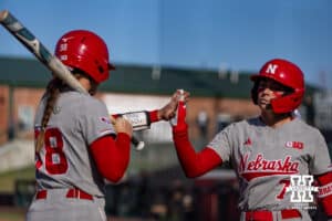 Nebraska Cornhusker Ava Kuszak (7) gives Jordyn Bahl (98) five after her at bat against the Purdue Boilermakers during a college softball game Monday, March 31, 2025 in Lincoln, Nebraska. Photo by John S. Peterson.
