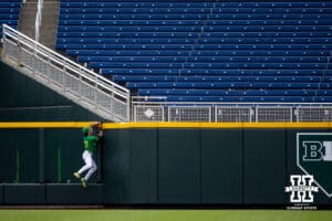 Oregon Duck catcher Anson Aroz (77) jumps up watching the ball go over the wall from a home run by Nebraska Cornhusker outfielder Gabe Swansen (44) in the first inning during the Big Ten Baseball Tournament on Saturday, May 24, 2025 in Omaha, Nebraska. Photo by John S. Peterson.