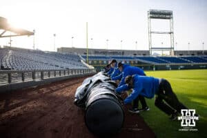 Grounds crew roll up the rain tarp from the night before for the Nebraska Cornhuskers vs. the Oregon Ducks game during the Big Ten Baseball Tournament on Saturday, May 24, 2025 in Omaha, Nebraska. Photo by John S. Peterson.