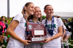 Three Pius X teammates pose for a picture with the state runner up trophy after the NSAA Girls Class B soccer finals on Monday, May 19, 2025, in Omaha, Nebraska. Photo by Braden Cochran.