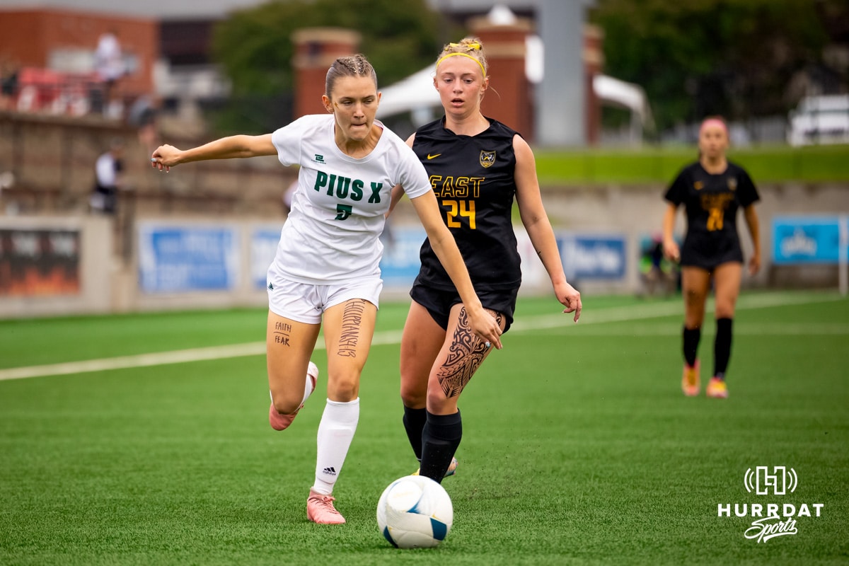 Pius X, Mackenzie Nickolite (5) moves up the field with Gretna East Defender Camryn Reeson (24) in pursuit during the NSAA Girls Class B soccer finals on Monday, May 19, 2025, in Omaha, Nebraska. Photo by Braden Cochran.