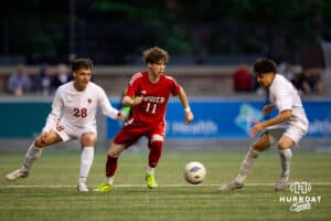 Guarded by South Sioux City, Hector Sandoval (28), Dylan Holden (11) pushes the ball towards the goal during the NSAA Boys Class A soccer semi-finals on Friday, May 16, 2025, in Omaha, Nebraska. Photo by Braden Cochran.