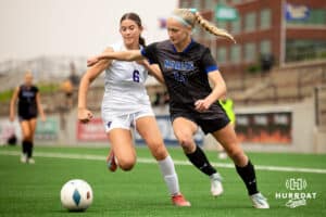 Marion Paige Miller (14, black) battles for the ball against Bellevue West's Brynlee Christensen (6) during the NSAA Girls Class A soccer semi-finals on Friday, May 16, 2025, in Omaha, Nebraska. Photo by Braden Cochran.