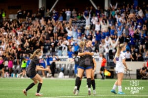 Omaha Marian teammates celebrate with Paige Miller (13) after the frist goal of the game during the NSAA Girls Class A soccer semi-finals on Friday, May 16, 2025, in Omaha, Nebraska. Photo by Braden Cochran.