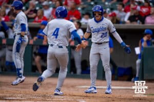Creighton Bluejays Tate Gillen (20) and Teddy Deters (4) score in the third inning against the Nebraska Cornhuskers during a college baseball game on Tuesday, May 6, 2025 in Lincoln, Nebraska. Photo by John S. Peterson.