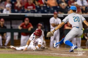 Arkansas Razorback Cam Kozeal (8) scores on a wild pitch against UCLA Bruin pitcher Justin Lee (20) in the eighth inning during the College World Series on Tuesday, June 17, 2025 in Omaha, Nebraska. Photo by John S. Peterson.