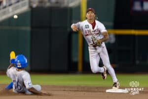 Arkansas Razorback infielder Wehiwa Aloy (9) turns a double play forcing out UCLA Bruin outfielder Dean West (36) out in the eighth inning during the College World Series on Tuesday, June 17, 2025 in Omaha, Nebraska. Photo by John S. Peterson.