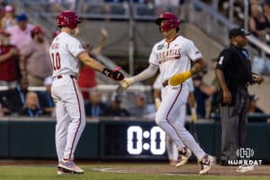 Arkansas Razorback infielder Wehiwa Aloy (9) celebrates his run in the seventh with a five from Brent Iredale against the UCLA Bruins during the College World Series on Tuesday, June 17, 2025 in Omaha, Nebraska. Photo by John S. Peterson.