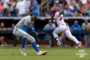 UCLA Bruin pitcher Cody Delvecchio (2) picks up the ball from a bunt by Arkansas Razorback Justin Thomas Jr. (4) to throw him out at first in the second inning during the College World Series on Tuesday, June 17, 2025 in Omaha, Nebraska. Photo by John S. Peterson.