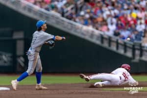 UCLA Bruin infielder Roch Cholowsky (1) turns a double-play against Arkansas Razorback pitcher Tate McGuire (26) in the second inning during the College World Series on Tuesday, June 17, 2025 in Omaha, Nebraska. Photo by John S. Peterson.