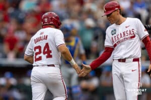 Arkansas Razorback outfielder Charles Davalan (24) gets five as he runs home from the home run by Arkansas Razorback infielder Wehiwa Aloy (9) in the first inning against the UCLA Bruins during the College World Series on Tuesday, June 17, 2025 in Omaha, Nebraska. Photo by John S. Peterson.