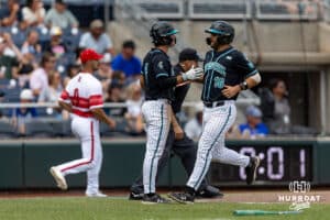 Coastal Carolina Chanticleer Colby Thorndyke (16) scores along with Walker Mitchell in the fifth inning against the Louisville Cardinals during the College World Series on Wednesday, June 18, 2025 in Omaha, Nebraska. Photo by John S. Peterson.
