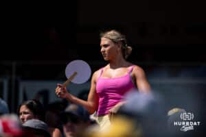 A fan fanning herself trying to stay cool from the heat watching Coastal Carolina Chanticleers and the Arizona Wildcats play during the College World Series on Friday, June 13, 2025 in Omaha, Nebraska. Photo by John S. Peterson.