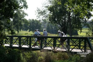 Golfers walk across a bridge during The Pinnacle Bank Championship on August, 7th, 2025 in Omaha Nebraska. Photo by Brandon Tiedemann.