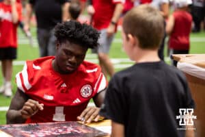 Nebraska Cornhusker Vincent Shavers Jr. (1) signs a poster for a fan during Nebraska’s football Fan Day on Saturday, Aug. 2, 2025 in Lincoln, Nebraska. Photo by John S. Peterson.
