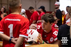 Nebraska Cornhusker Conor Booth (23) signs a helmet for a young fan during Nebraska’s football Fan Day on Saturday, Aug. 2, 2025 in Lincoln, Nebraska. Photo by John S. Peterson.