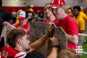 Nebraska Cornhusker Trent Uhlir (32) signs a wooden cutout of Nebraska during Nebraska’s football Fan Day on Saturday, Aug. 2, 2025 in Lincoln, Nebraska. Photo by John S. Peterson.