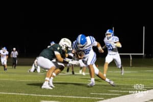 Quarterback Ty Buaphakeo (12) lowers his shoulder in preparation for contact from a Gretna defender during a High School Football game, Friday, September 26th, 2025, Gretna, Nebraska. Photo by Braden Cochran.