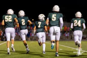 Gretna offensive players; Lathan Jones (52), Talon Daharsh (2), Joe Sullivan (7), Micheal Knudsen (5), and Ayden Fursteneau (24) make their way to the field after a change off possesion during a High School Football game, Friday, September 26th, 2025, Gretna, Nebraska. Photo by Braden Cochran.